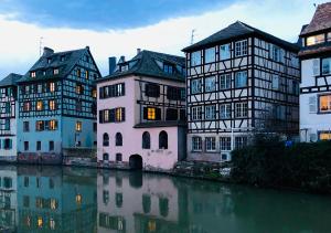 un groupe de bâtiments à côté d'une rivière dans l'établissement Maison duplex, avec terrasse dans Strasbourg, à Strasbourg