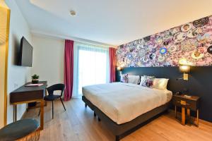a hotel room with a large bed and a desk at Hôtel La Villa Port d'Antibes & Spa in Antibes