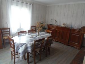 ein Esstisch mit einer Vase mit Blumen darauf in der Unterkunft maison de vacances in Grandcamp-Maisy + 12 Fotos
