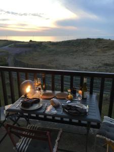 a table with food on top of a balcony at Face à la mer à Cabourg in Cabourg