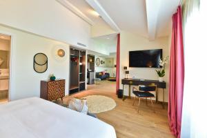 1 dormitorio con 1 cama y escritorio con TV en Hôtel La Villa Port d'Antibes & Spa, en Antibes