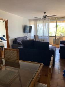 a living room with a blue couch and a tv at Face à La Mer in Calafell