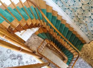 eine Wendeltreppe in einem Gebäude mit Grün und Braun in der Unterkunft Hôtel The Originals Résidence de Rohan (EX RELAIS DU SILENCE) in Vaux-sur-Mer