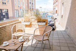 eine Terrasse mit zwei Stühlen und einem Tisch mit Tassen darauf in der Unterkunft Beachhouse Anna, 1 minute walk to the beach and centre of Katwijk, Free private parking next to the house ! in Katwijk aan Zee