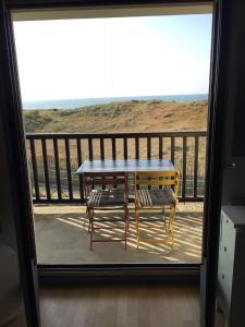 a table and two chairs on a balcony at Face à la mer à Cabourg in Cabourg