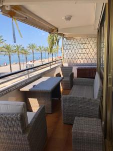 een restaurant met stoelen en tafels en uitzicht op het strand bij Face à La Mer in Calafell