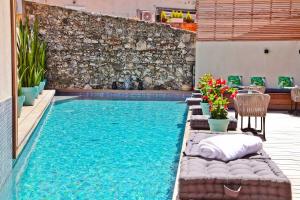 a swimming pool in a backyard with a table and chairs at Hôtel La Villa Port d'Antibes & Spa in Antibes