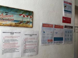 a sign on a wall with a picture of the beach at Fonte da Telha Beach Hostel in Costa da Caparica