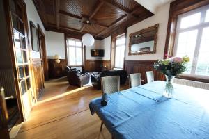 una sala de estar con una mesa con un jarrón de flores. en Gite Logis des Fontaines, en Raon-lʼÉtape