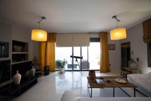 a living room with yellow curtains and a large window at NIAN villa sea in Drosia