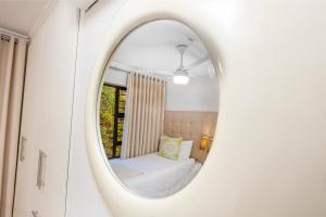a mirror in a room with a bed and a couch at 14 The Shades - by Stay in Umhlanga in Durban