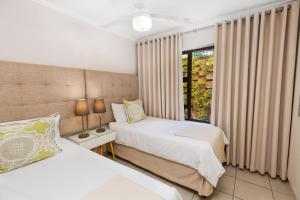 a bedroom with two beds and a window at 14 The Shades - by Stay in Umhlanga in Durban