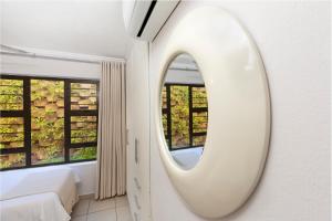 a white mirror in a bedroom with windows at 14 The Shades - by Stay in Umhlanga in Durban