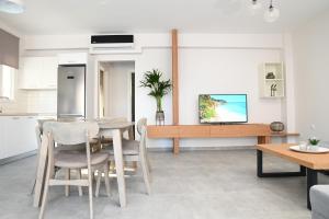 a kitchen and dining room with a table and chairs at Faidra Apartments in Nea Peramos