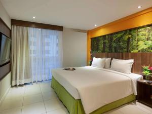 a bedroom with a large bed and a large window at Mercure Rio de Janeiro Nova Iguaçu in Nova Iguaçu