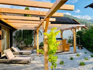 a wooden pergola with chairs and a table at Victoria Retreat & Spa in Vercorin