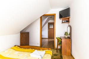1 dormitorio con 1 cama, escritorio y TV en Willa Aleksander, en Władysławowo