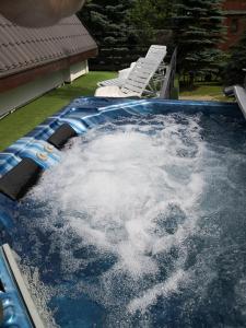 Una piscina llena de agua con dos sillas. en Chata Sofia Námestovo, en Námestovo