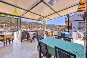 a balcony with tables and chairs and a view at Santosa Pension in Kaş