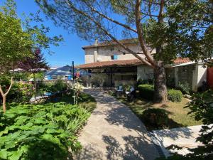 a house with a tree and a walkway at Hostellerie Les Griffons in Brantome en Perigord