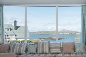 a couch in a living room with a view of the ocean at Porth Diana House - 4 Bed-Sleep10-Trearddur Bay in Trearddur