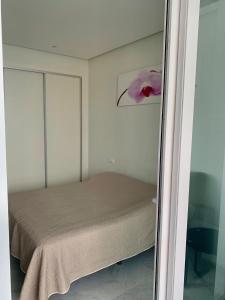 sypialnia z łóżkiem z różowym kwiatem na ścianie w obiekcie Precioso piso con unas vistas increíbles w mieście Benidorm