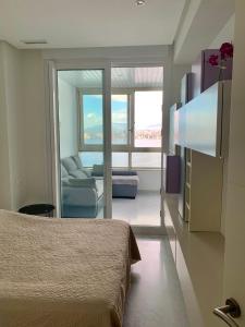 um quarto com uma cama e uma sala de estar com um sofá em Precioso piso con unas vistas increíbles em Benidorm