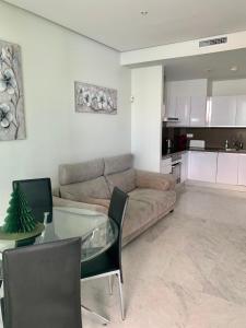 salon z kanapą i szklanym stołem w obiekcie Precioso piso con unas vistas increíbles w mieście Benidorm