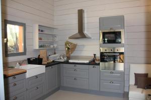 eine Küche mit weißen Schränken und einem Herd mit Backofen in der Unterkunft Gîtes "Les Cabanes de Carelle" entre Camargue et Cévennes in Aspères