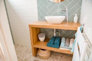 ein Badezimmer mit einem Waschtisch aus Holz und einem Waschbecken in der Unterkunft Beachhouse Anna, 1 minute walk to the beach and centre of Katwijk, Free private parking next to the house ! in Katwijk aan Zee