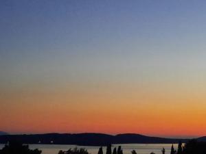 a group of people standing in front of a lake at sunset at Villa Malisko in Hvar