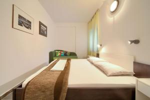 1 dormitorio pequeño con 1 cama y 1 silla en Apartments Dubravka en Krk