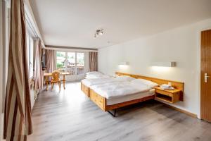 A bed or beds in a room at Roggenstock Lodge