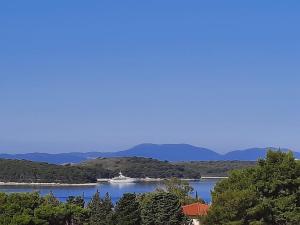 a boat on a lake with mountains in the background at Villa Malisko in Hvar