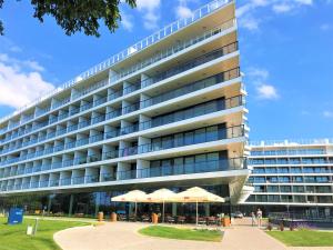 duży budynek z parasolami przed nim w obiekcie 6 piętro Seaside w Kołobrzegu