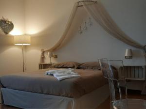 a bedroom with a large bed with a canopy at Regina di Cuori Rooms in SantʼElpidio a Mare