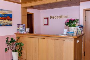 a reception counter in a room with flowers at Hotel Englischer Hof in Herzberg am Harz