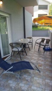 a patio with a table and chairs and an umbrella at PremiumPlus Apartman in Vrnjačka Banja