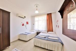 a bedroom with two beds and a window at Santosa Pension in Kaş