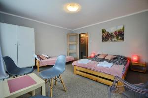 um quarto com 2 camas, uma secretária e cadeiras em Apartament ANWAN em Wisla