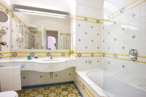 a bathroom with a tub and a sink at Grand Hotel La Favorita in Sorrento