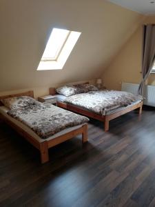 two beds sitting in a room with a skylight at Pokoje gościnne Alicja in Kudowa-Zdrój