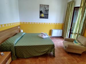 a bedroom with a green bed and a chair at Residence Ristorante Baobab in Controguerra