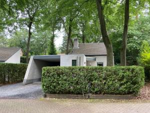 a white house with a hedge in front of it at Huize Nuwenspete in Nunspeet