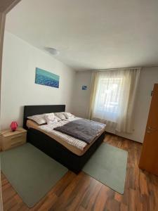 Schlafzimmer mit einem Bett und einem Fenster in der Unterkunft Privat Zimmer KF in Knittelfeld