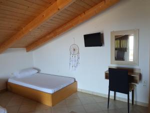 a bedroom with a bed and a desk and a window at Ionion Studios in Kanali