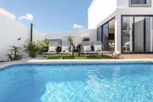 a swimming pool in front of a house at Villa Abeto in Yaiza