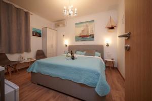 a bedroom with a bed with two dogs sitting on it at Rooms Antonio in Trogir