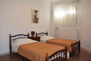 a bedroom with two beds and a window at Karagiannis in Keramoti +13 photos
