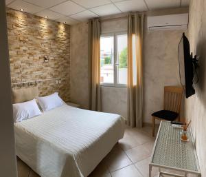 Un pat sau paturi într-o cameră la Hôtel Le Derby